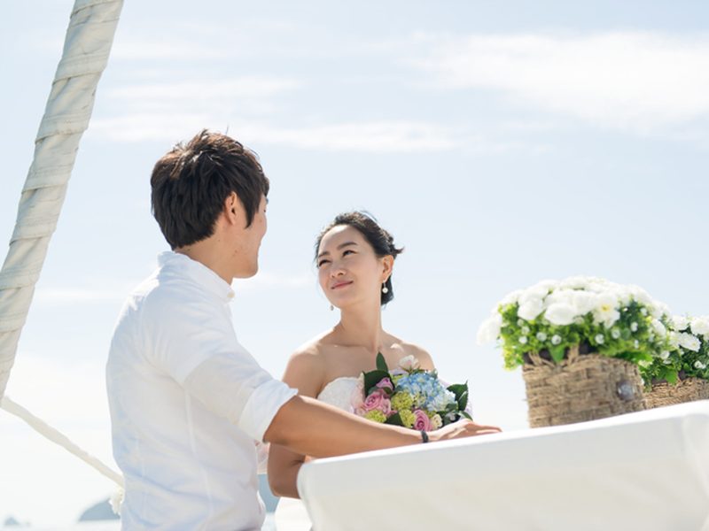 ヨットのデッキで向かい合う新郎新婦